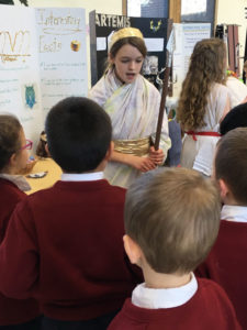 girl in Greek Goddess costume talking with students