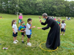 Fr. Bergida and children on field